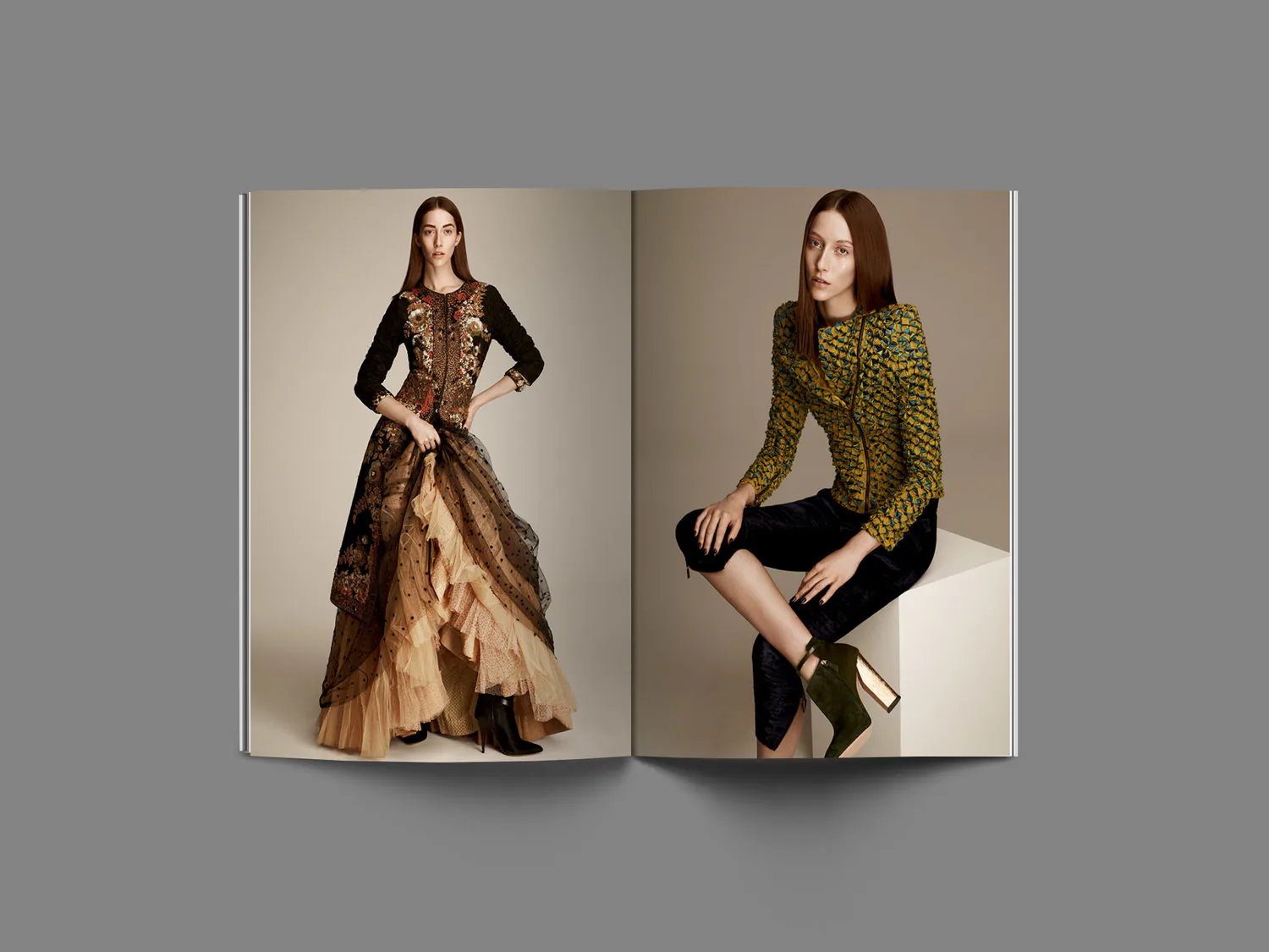 A brand book open on a spread, two models in embellished couture.