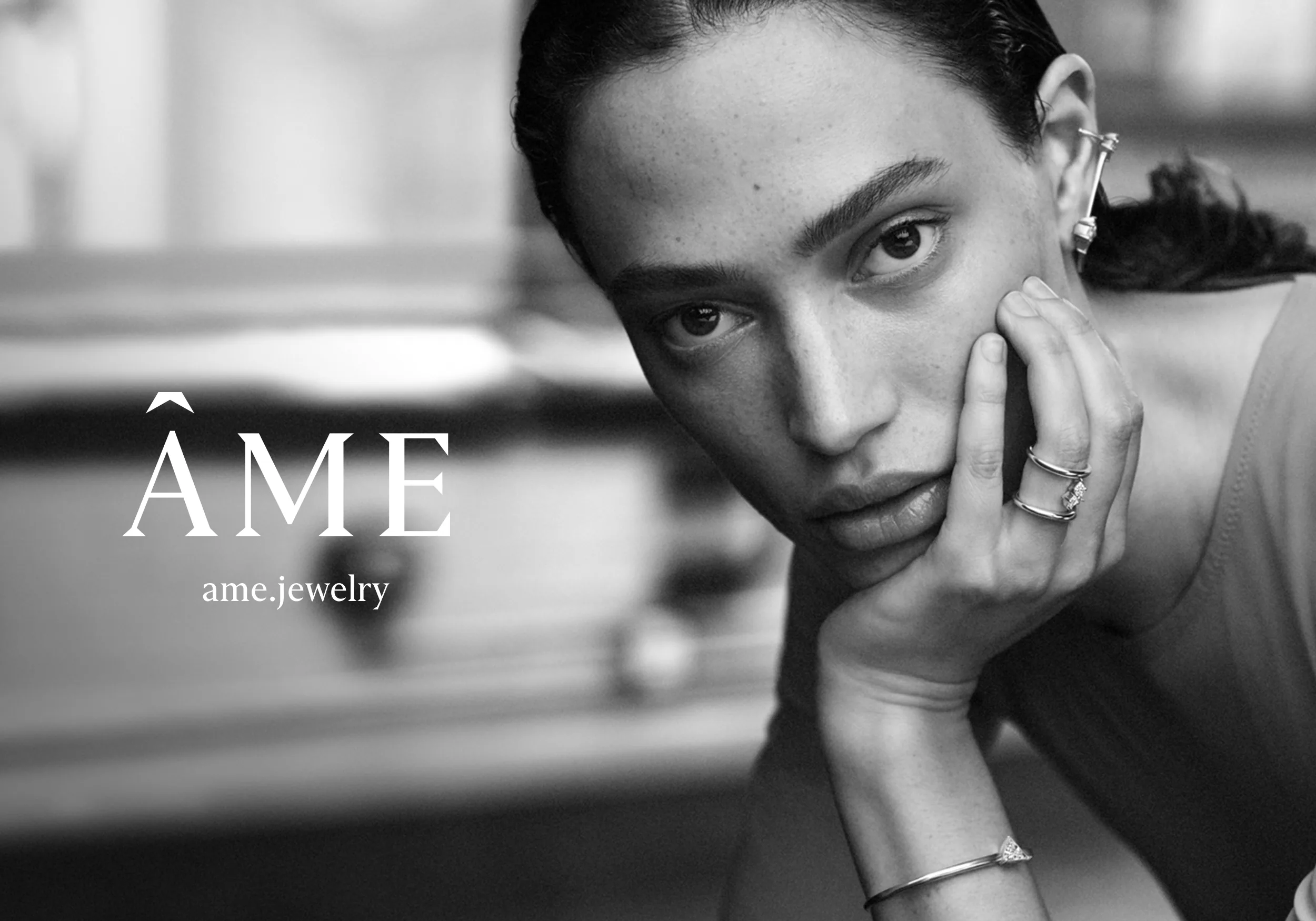 The Ame wordmark beside a portrait of a model wearing earrings.