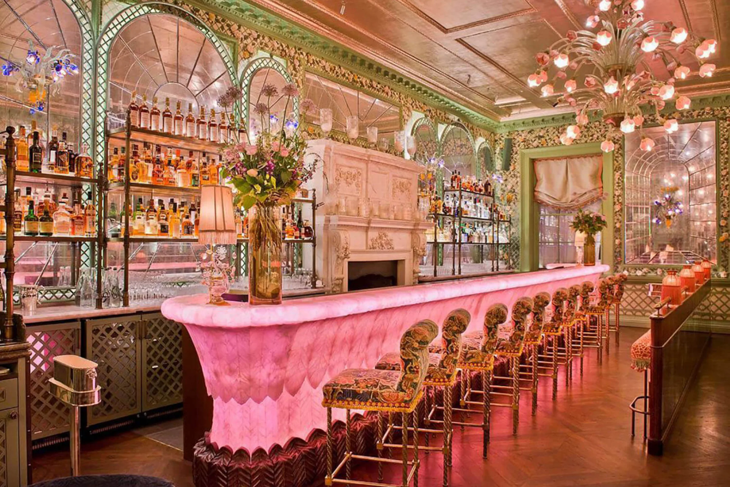 The pink onyx bar at Annabel's, with upholstered stools along its length.