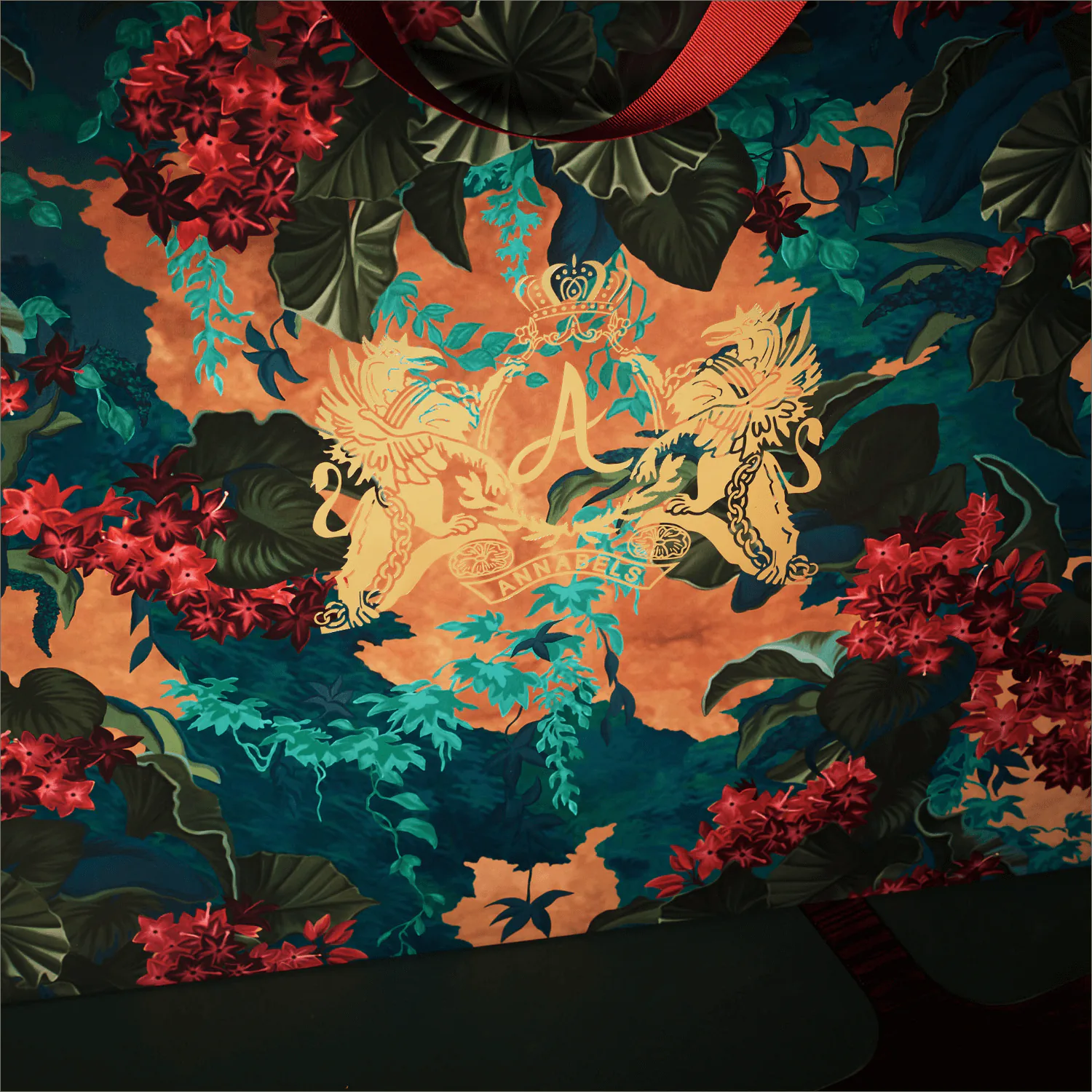 The floral print in close up, with a gilded crest at its centre.