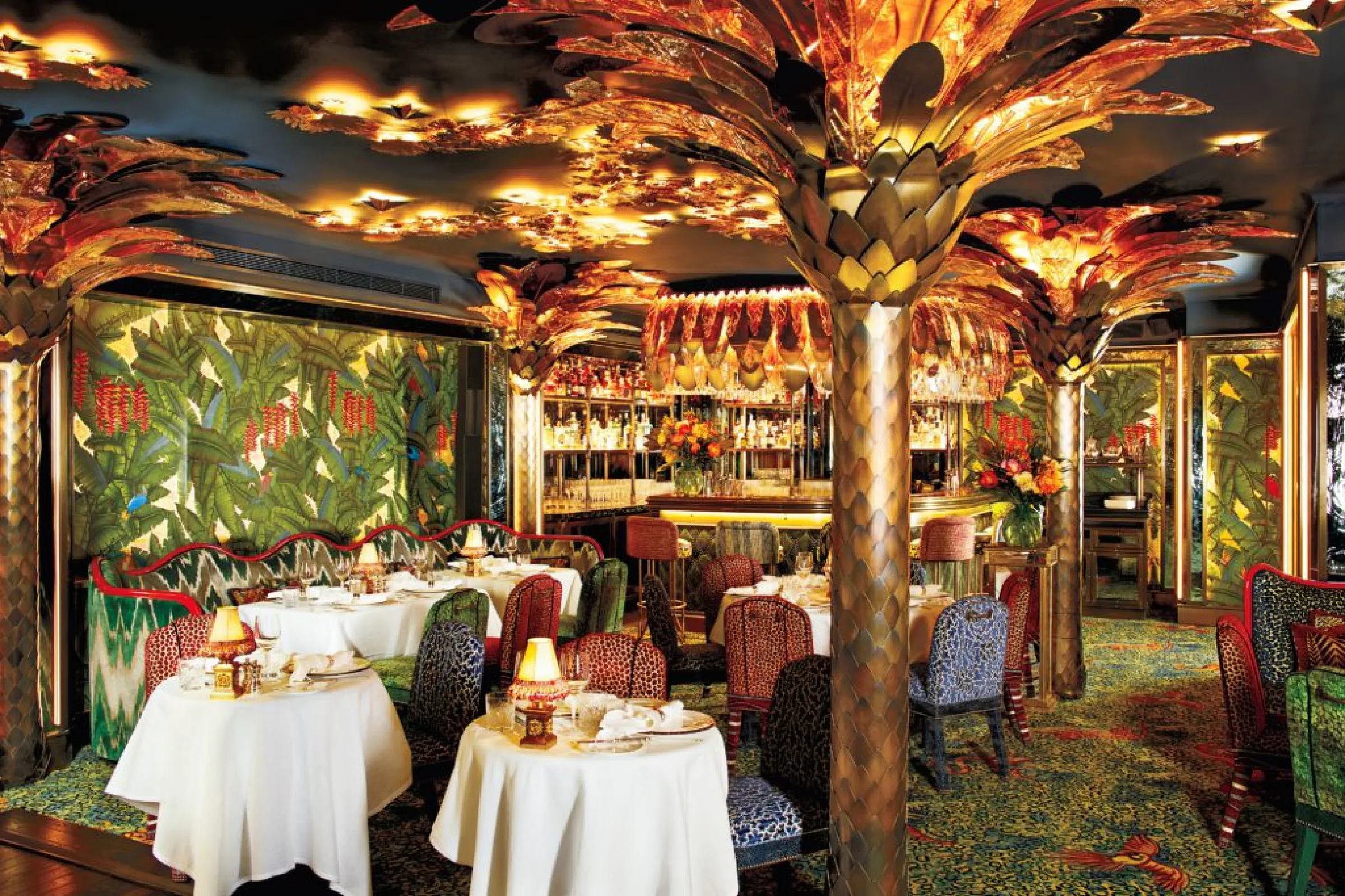 A dining room at Annabel's, with palm tree columns and laid tables.