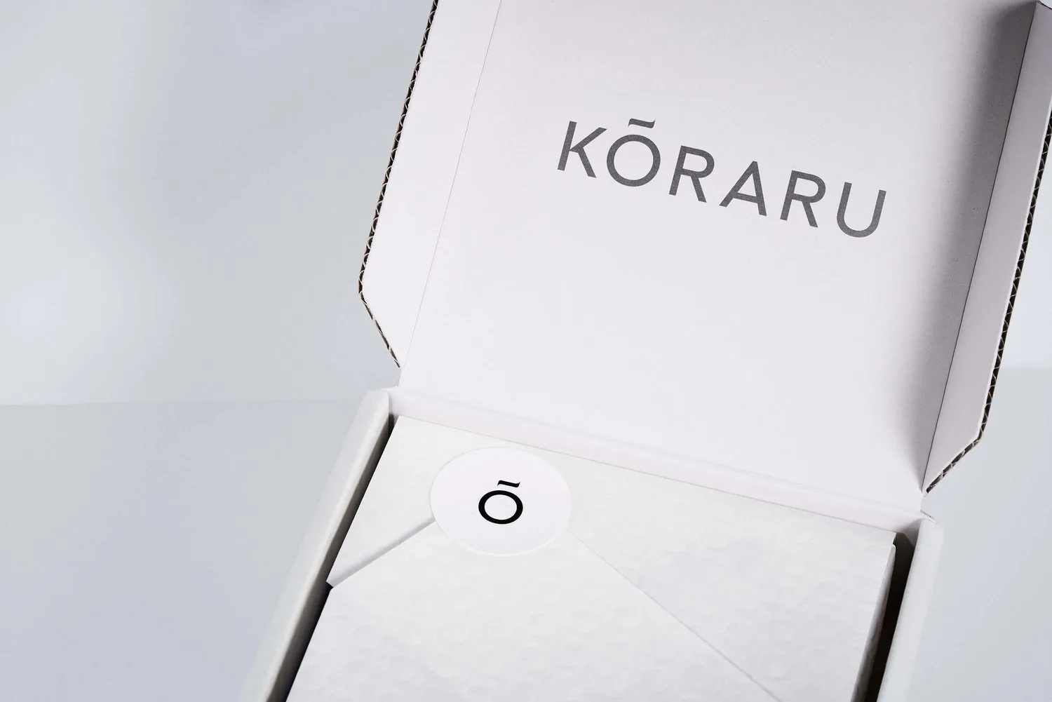 An open white Koraru box, the name printed inside the lid.