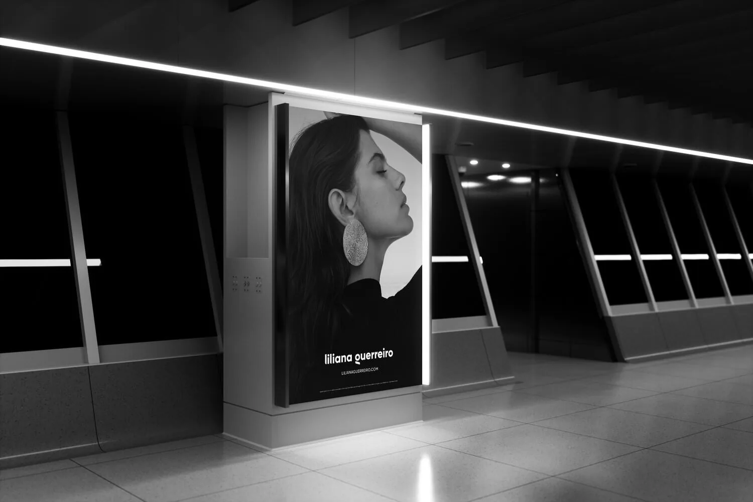 A lit billboard in a dark underpass showing a portrait, in black and white.