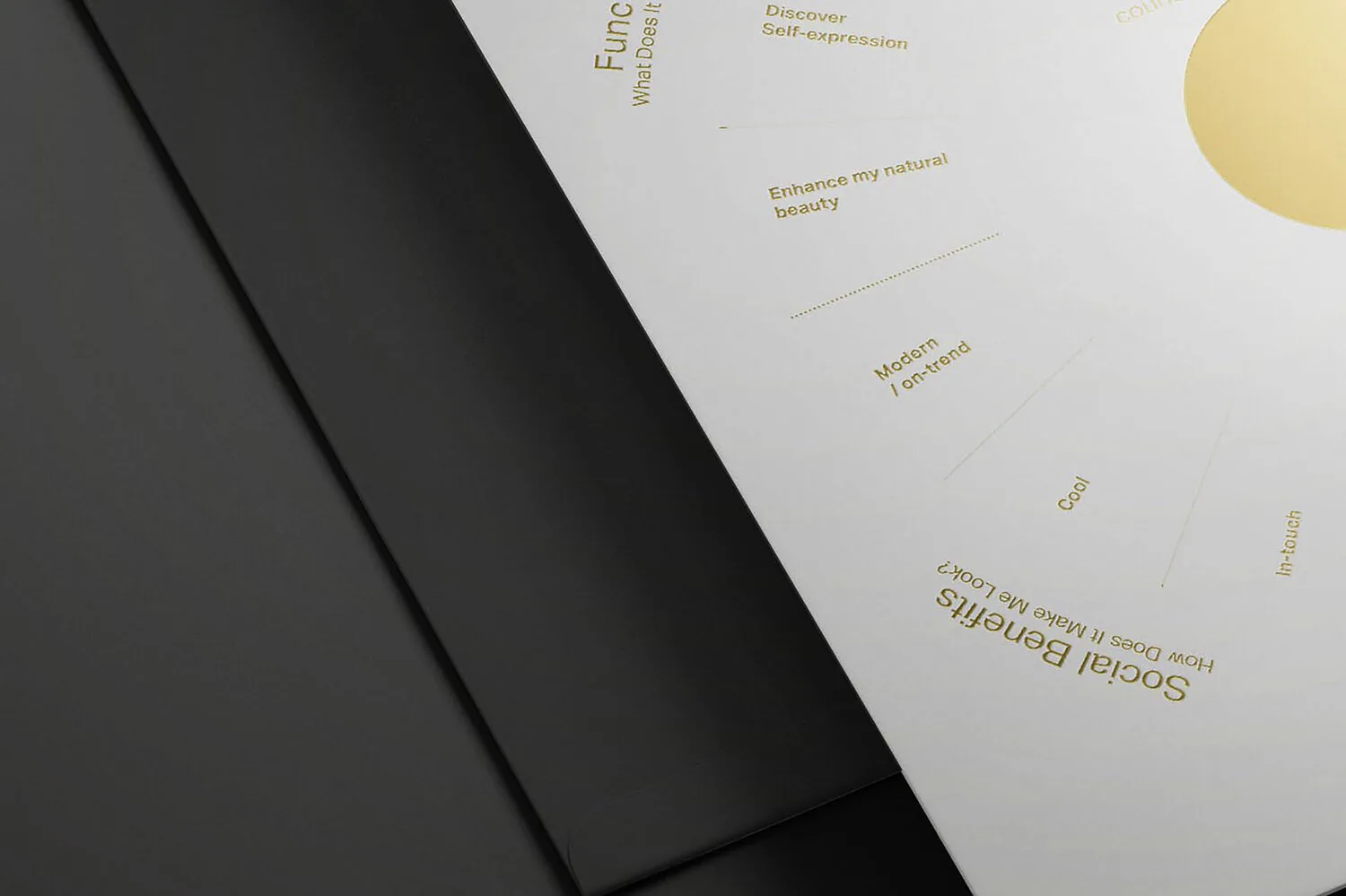 A black folder beside a pale printed sheet with gold type and a gold arc.
