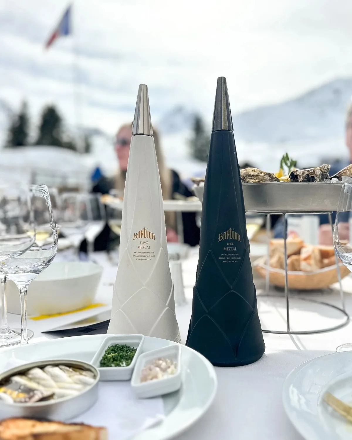 Two Bandida bottles on a laid table, mountains beyond.