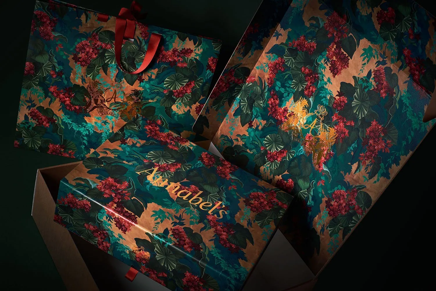 Annabel's gift boxes in teal printed with red and gold flowers, one lying open.