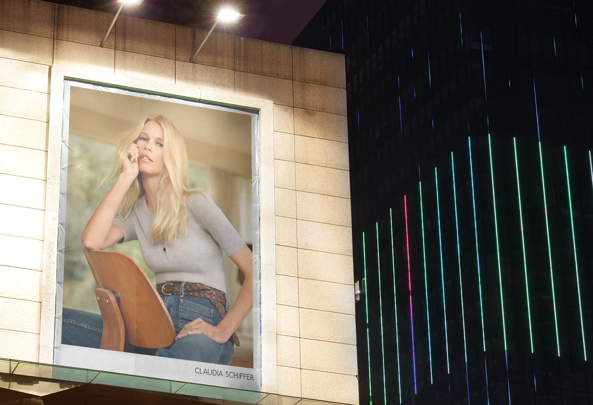 A campaign poster in a lit shop window beside a wall of coloured light.