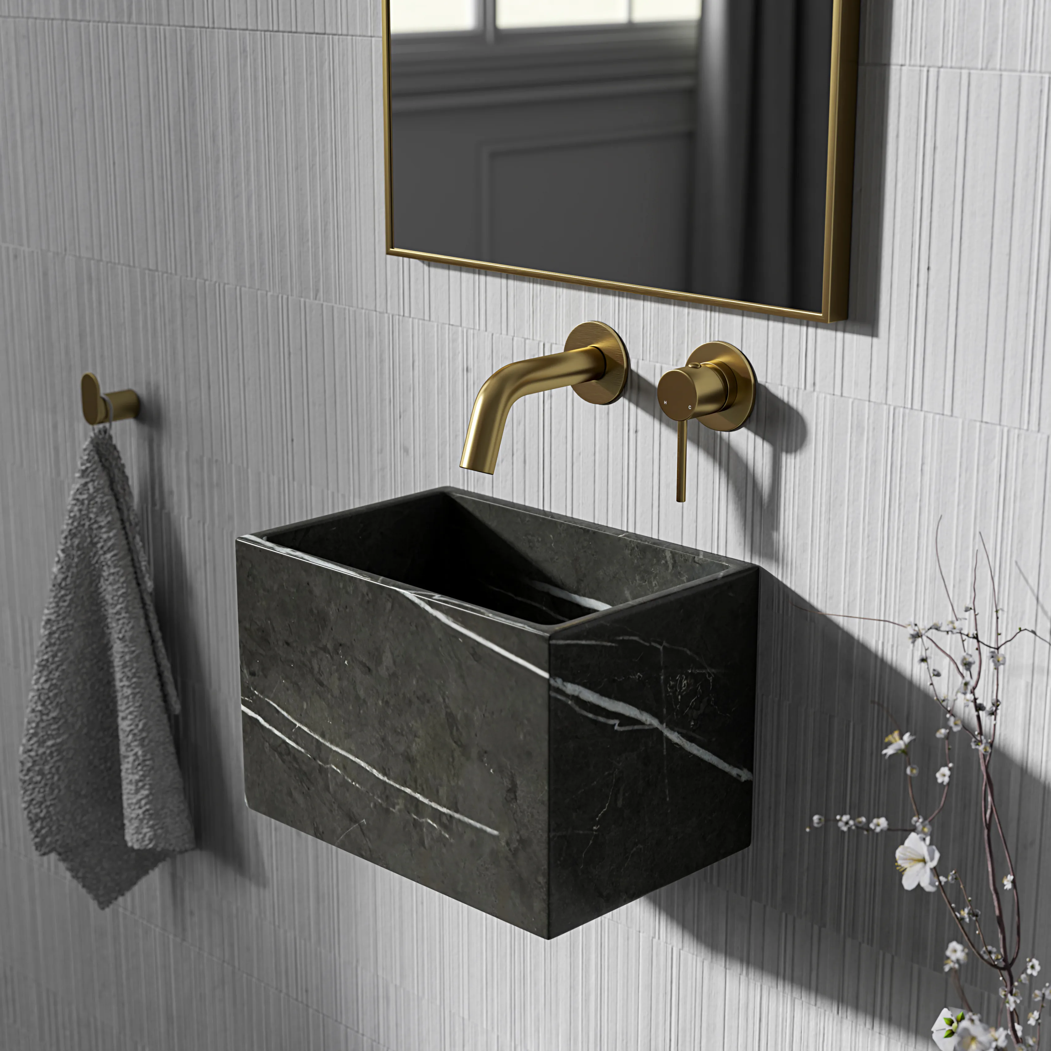 A black marble basin on a ribbed white wall, with a brass wall tap and a mirror above.