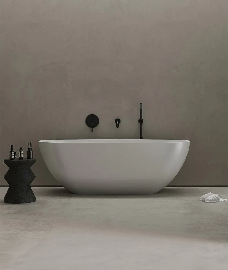 A freestanding bath in a stone-coloured room.