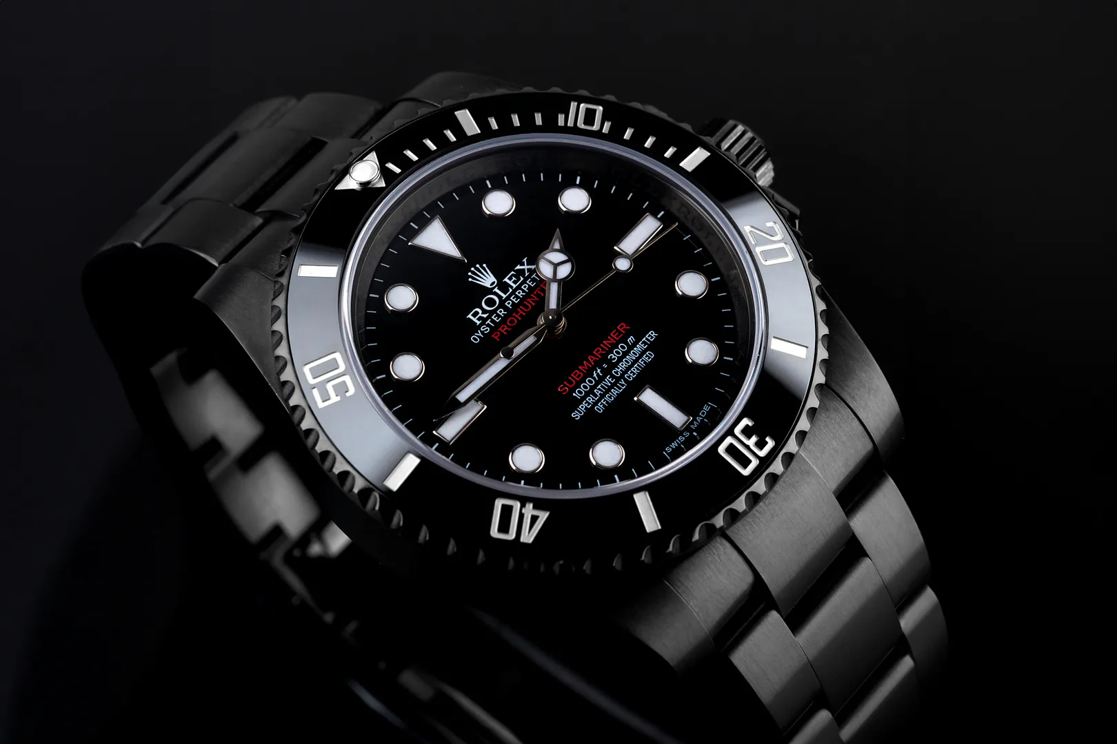 A blacked-out Rolex Submariner on its steel bracelet, lit against a dark ground.