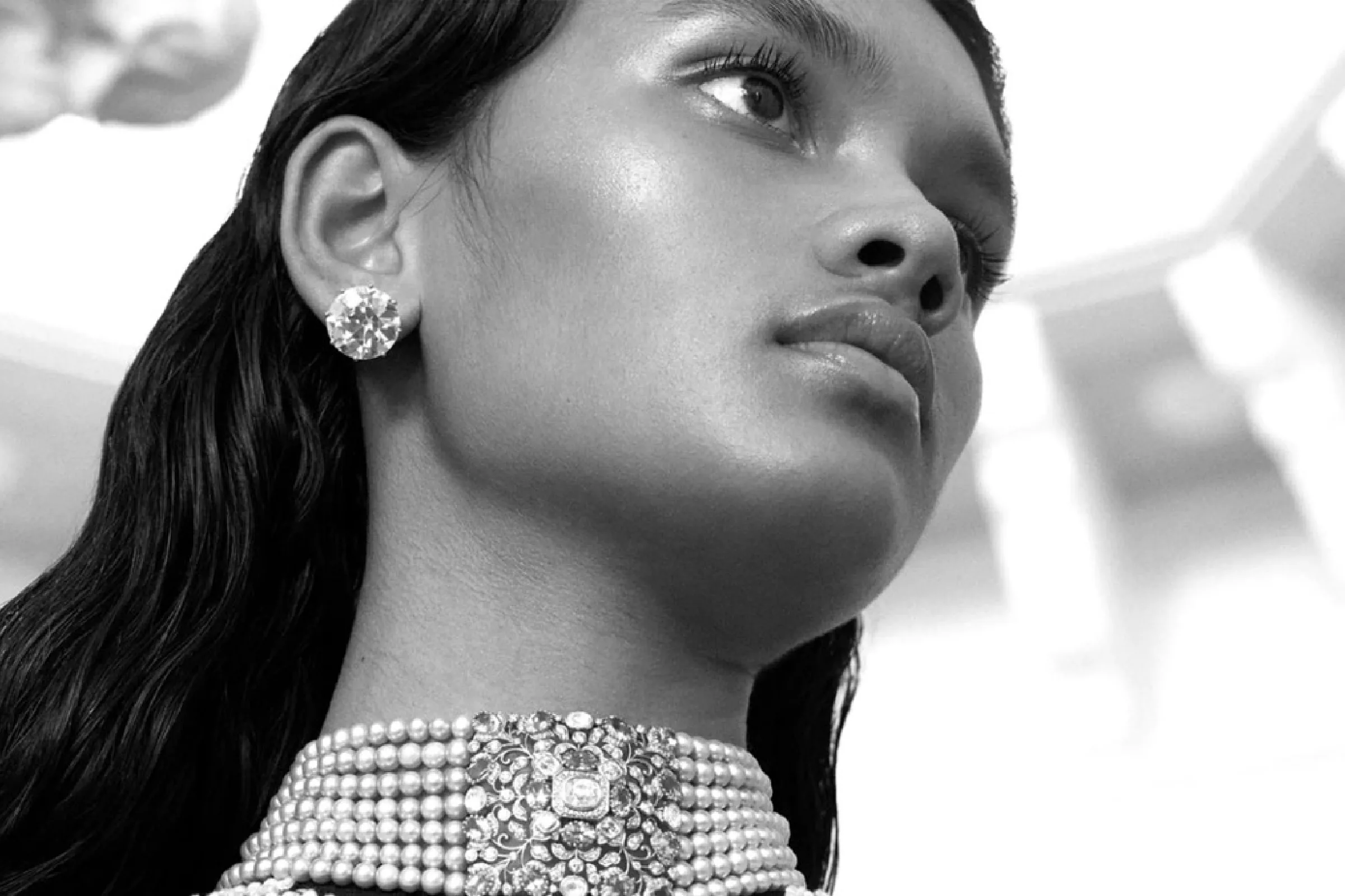 A model in a diamond choker and matching earrings, in black and white.