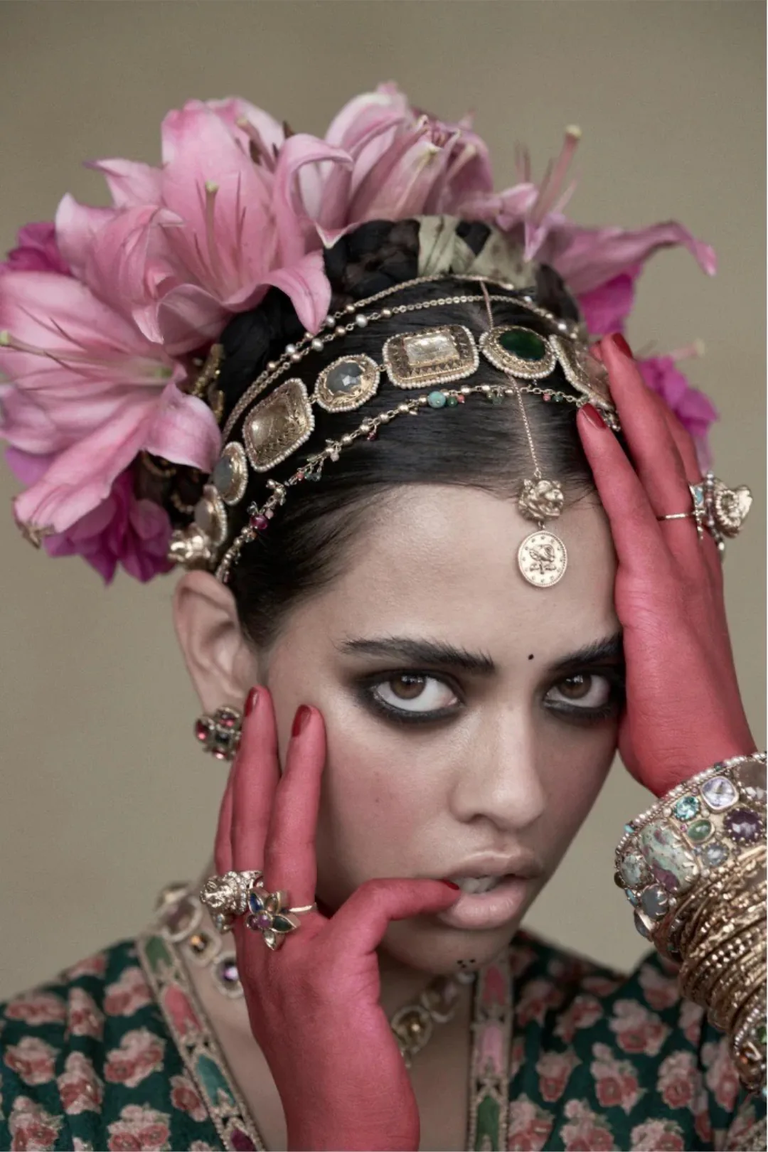 A model in a feathered headdress with layered jewellery.