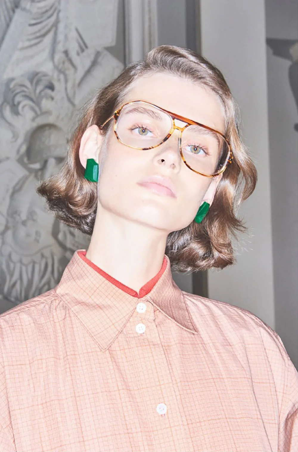 A model wearing Victoria Beckham eyewear and a pink shirt.