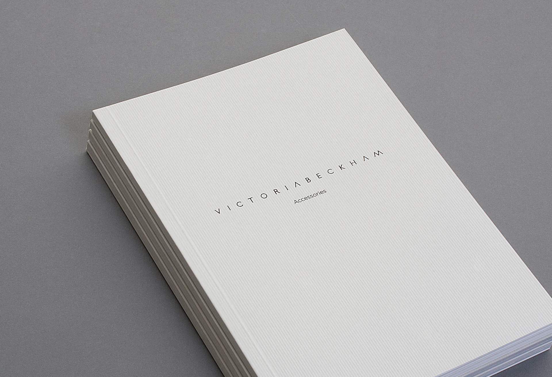 A stack of white brochures with the wordmark on the cover.